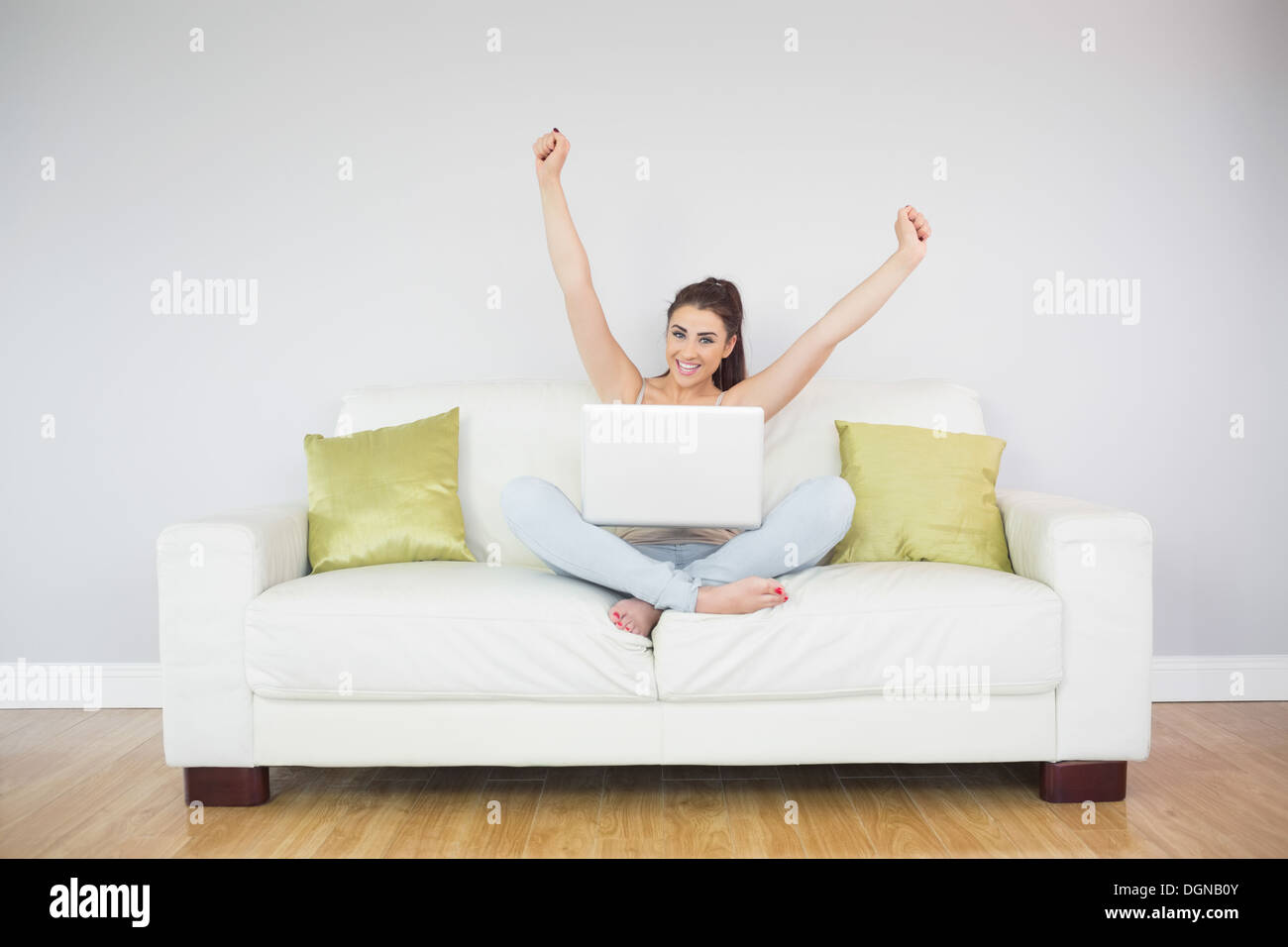 Junge jubelnde Frau mit ihrem notebook Stockfoto