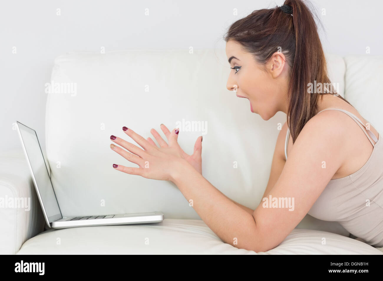 Begeistert junge Frau ihren Laptop nutzen Stockfoto