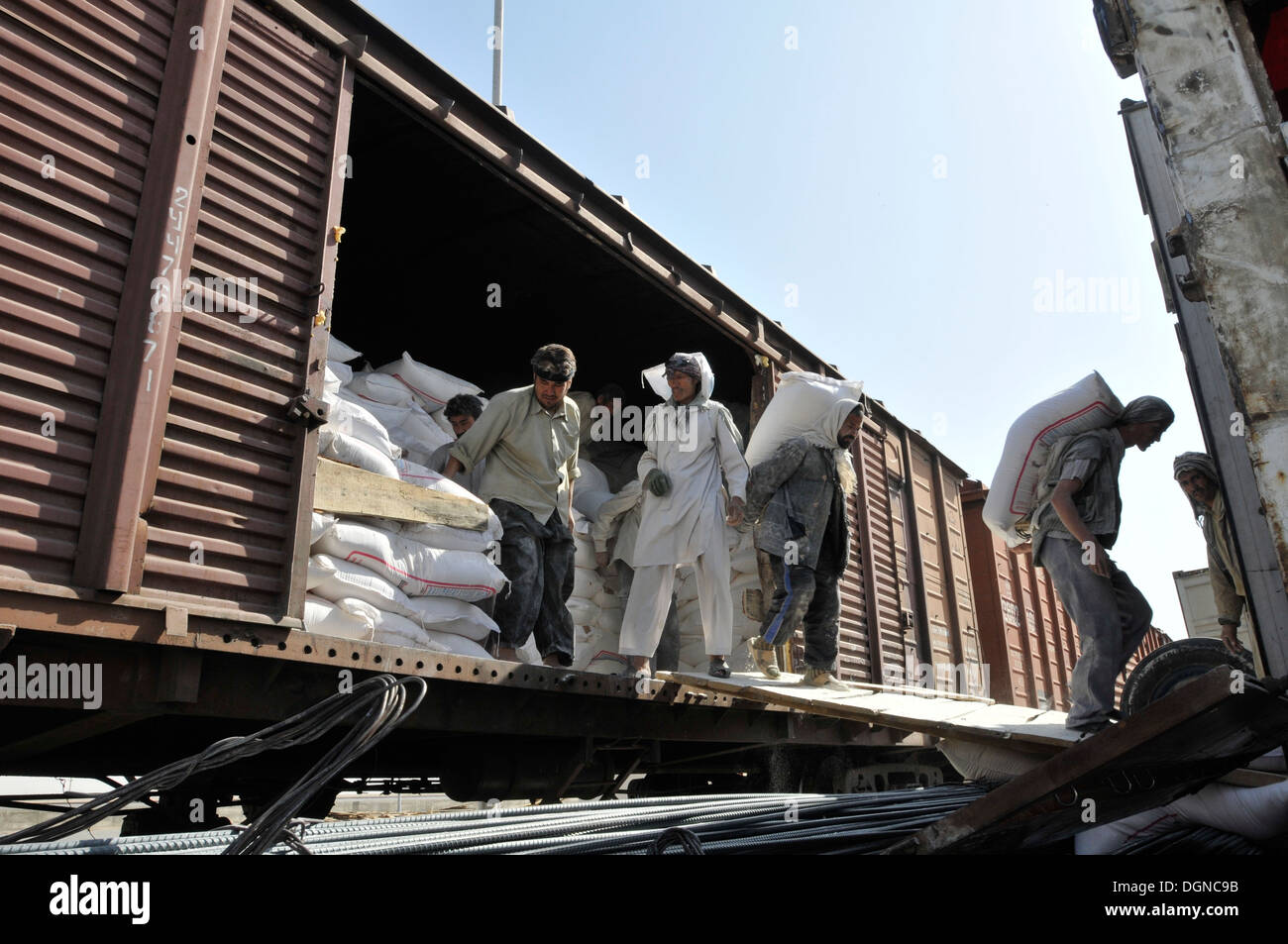 Rail-Port 4, Niababad, beginnen afghanische Arbeiter die manuell intensive auslagern 100 Pfund plus Taschen von Backmehl aus einem Güterwagen auf Semi-LKW für den Transport nach Afghanistan Märkte warten. Das Mehl wurde durch Usbekistan importiert. Stockfoto