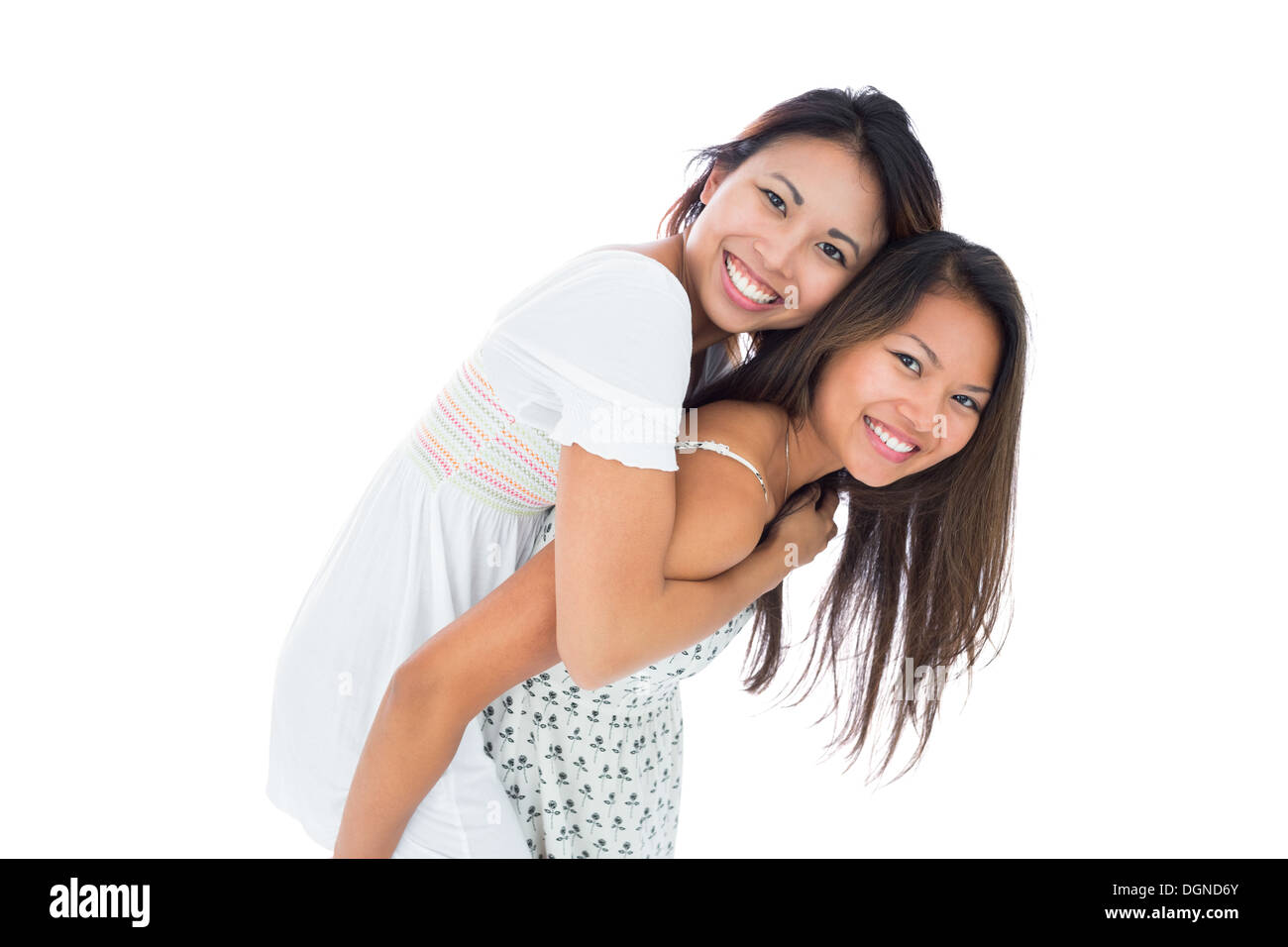 Asiatische Frau geben ihre Schwester eine Huckepack Fahrt lächelnd Stockfoto