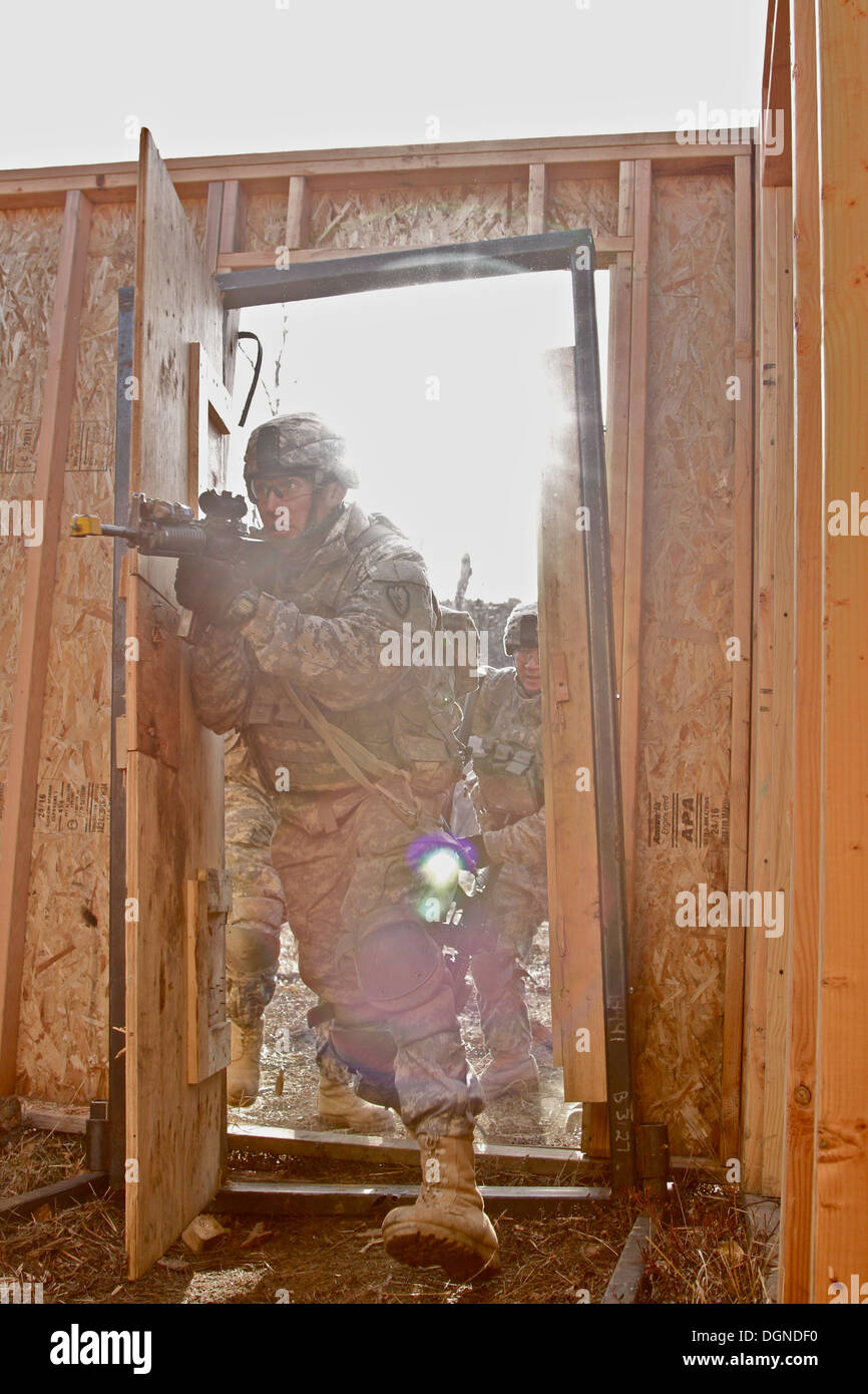 Sgt. Kaleb Stroud, Teamleiter im Unternehmen C, 1. Bataillon, 24. Infanterie-Regiment, 1st Stryker Brigade Combat Team, 25. Infanterie-Division, führt sein Team in ein Gebäude während einer leere-Feuer Übung in Alaska Yukon-Trainingsbereich, 22 Oktober. Stockfoto