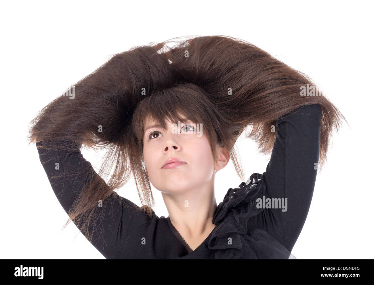 Attraktive junge Frau mit schöne lange gerade brünette Haare durchlaufen die locken heben ihre Hände Stockfoto