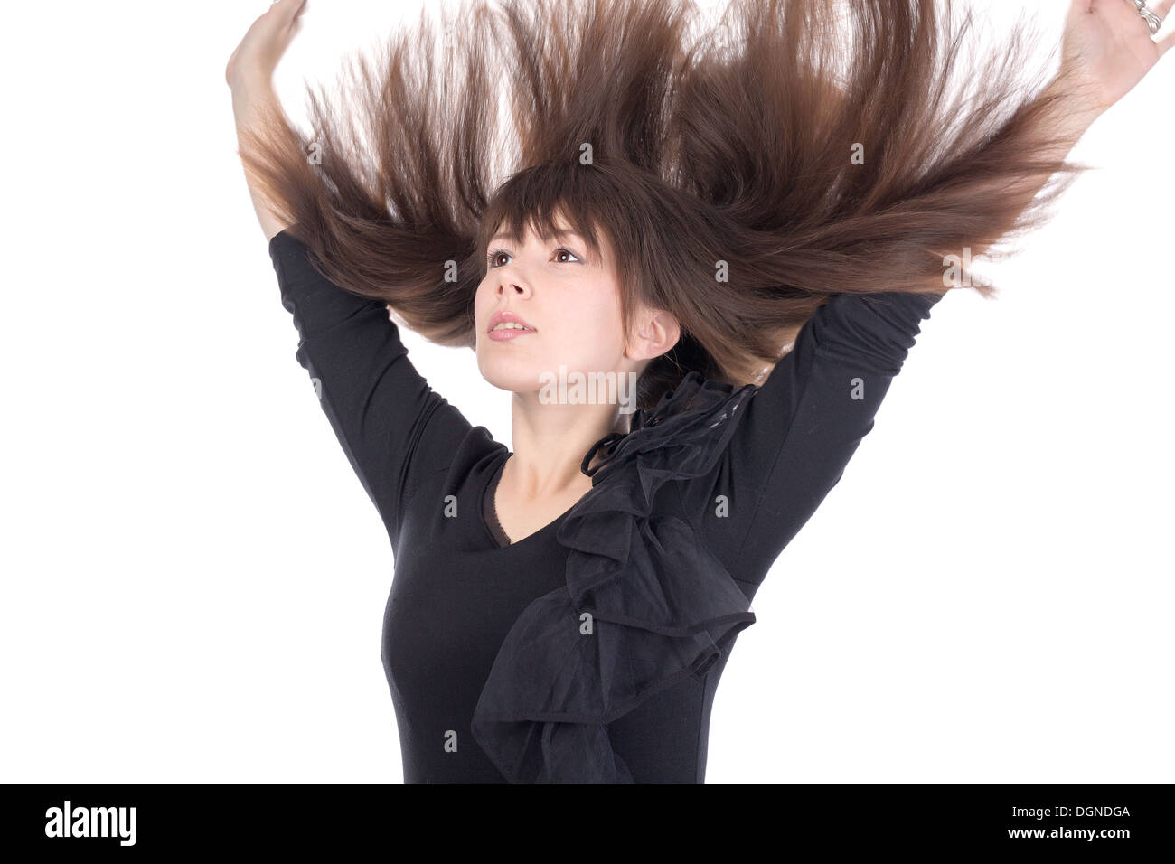 Junge Frau mit ihrem lange gerade brünette Haare fliegen in der Luft und ihre Arme über den Kopf, isoliert auf weiss Stockfoto