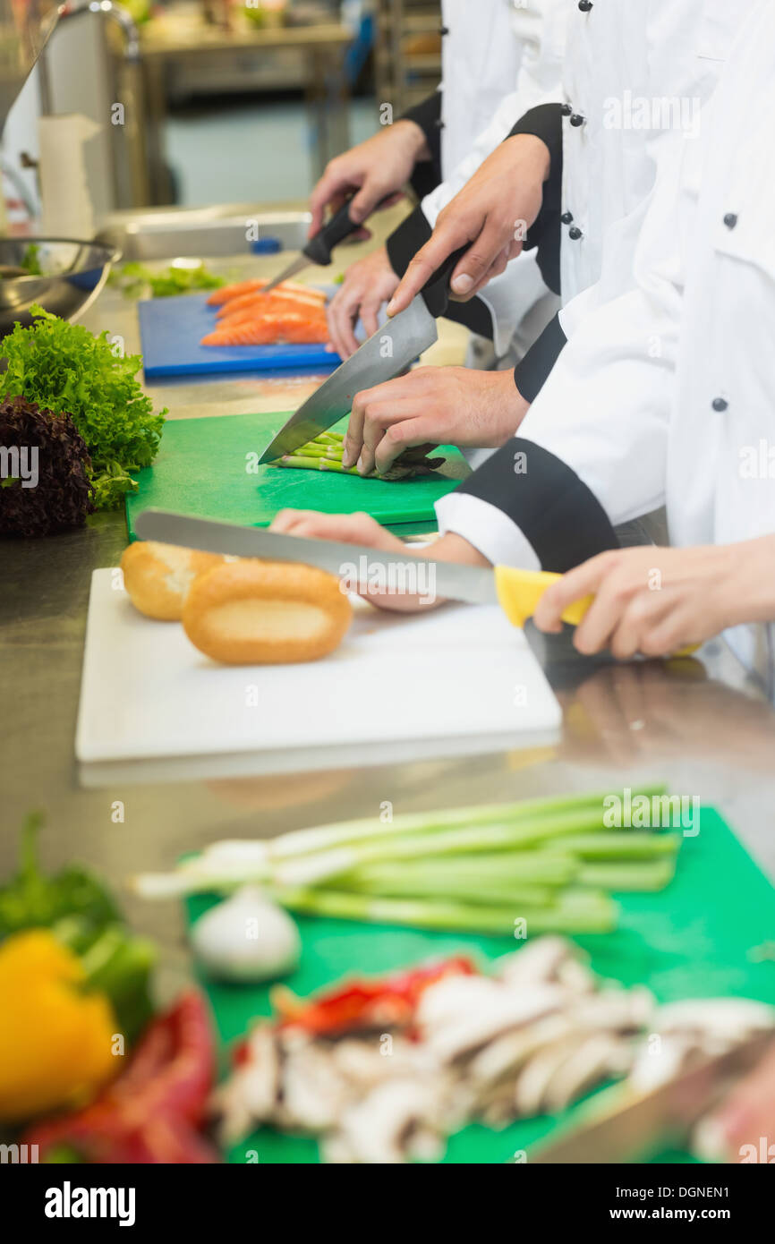 Nahaufnahme der Köche schneiden Brot Brötchen Spargel und Lachs Stockfoto
