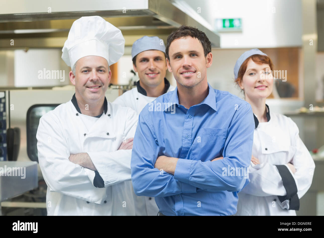 Junge Manager posiert mit einige Köche Stockfoto
