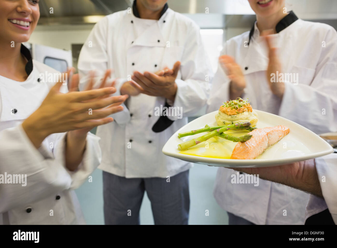Junge Köche applaudieren Lachse Gericht Stockfoto