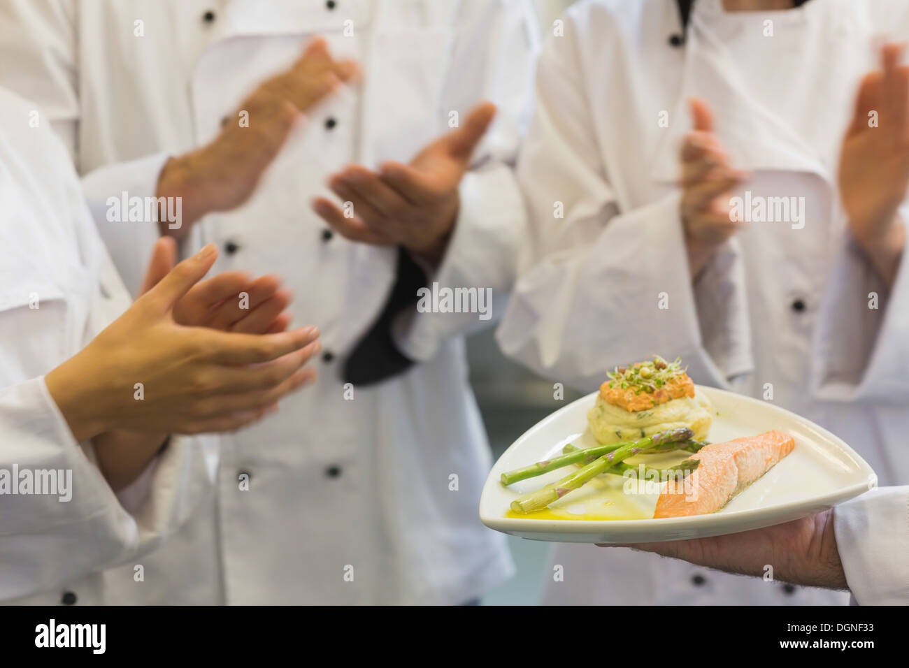 Köche, die applaudieren Lachs Gericht Stockfoto