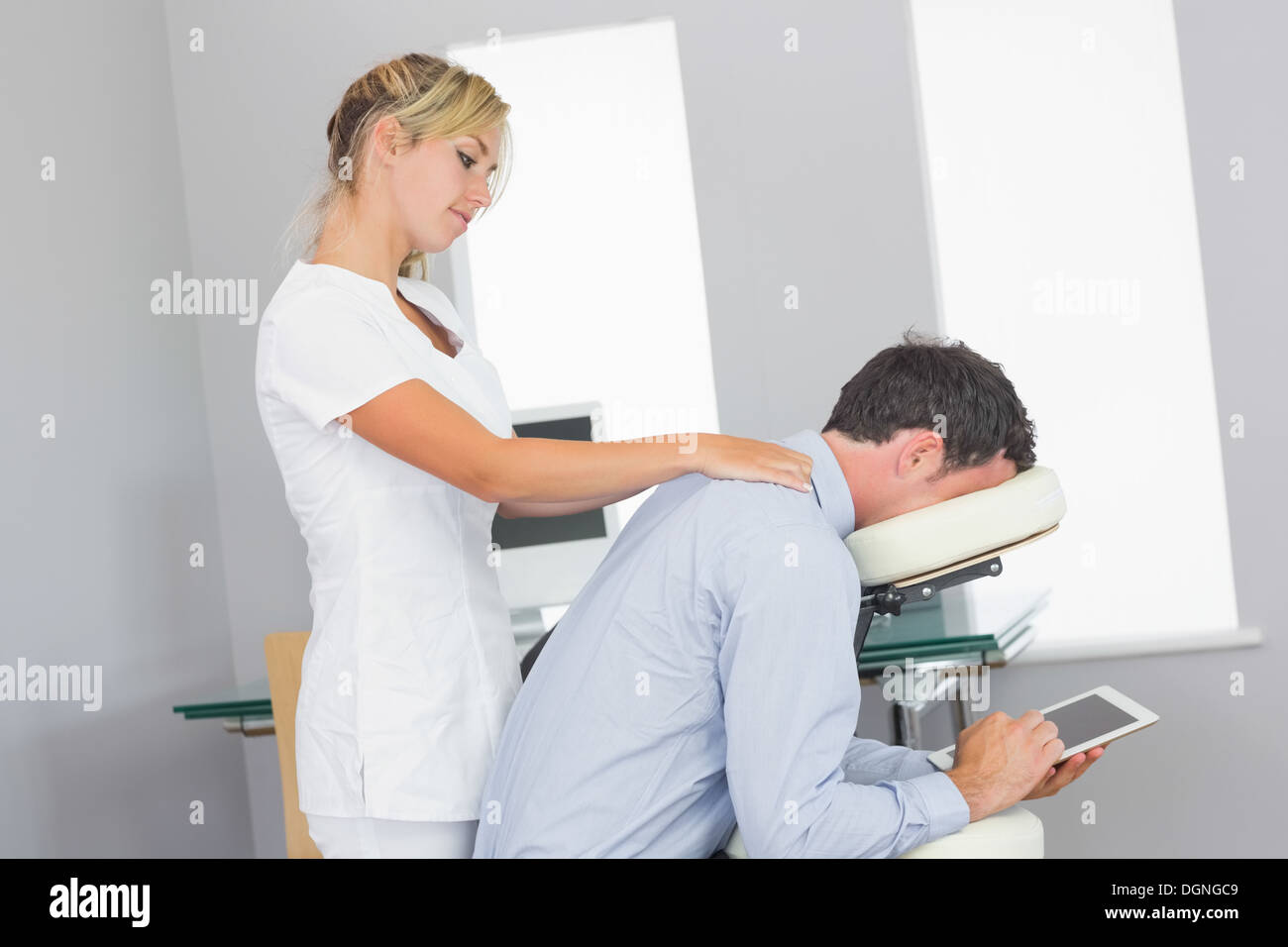 Masseurin massieren Kunden Hals in Massage-Stuhl Stockfoto