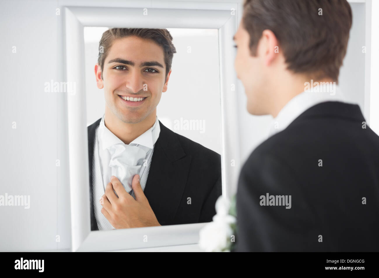 Fröhliche junge Bräutigam stehen vor einem Spiegel Stockfoto