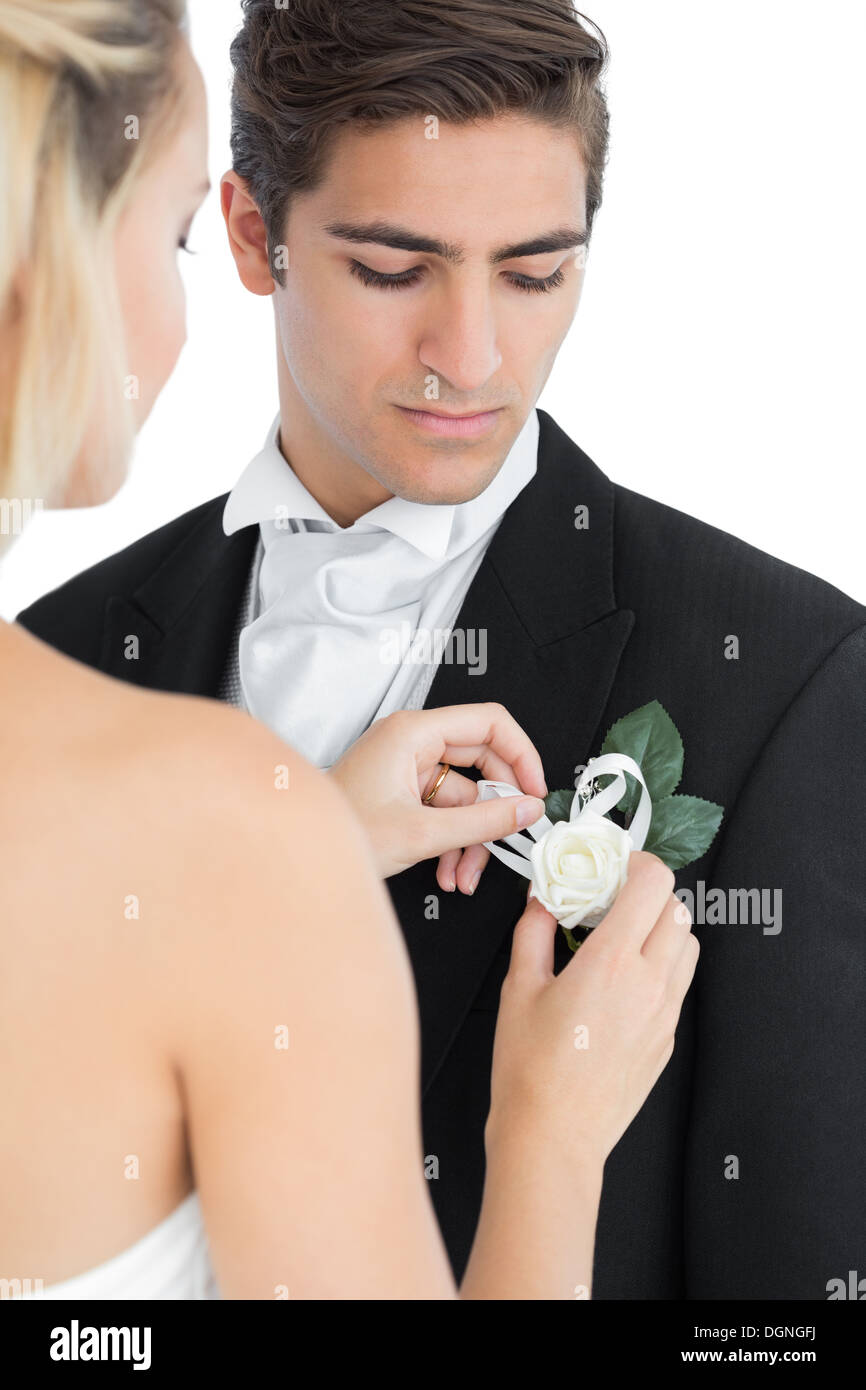 Junge Braut Anheften einer Blume auf ihre Ehemänner-Anzug Stockfoto