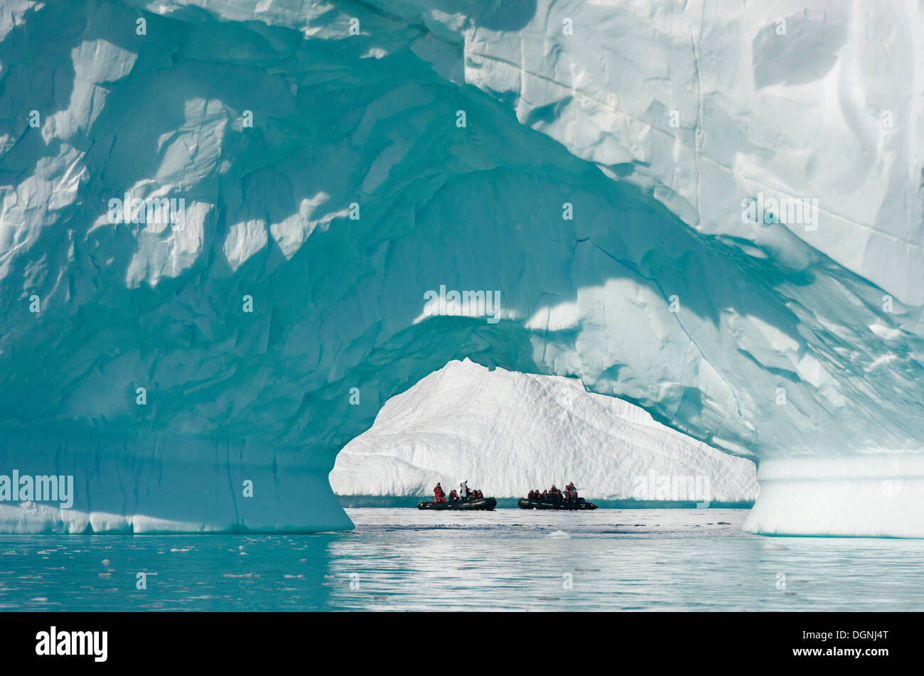Zodiac Schlauchboote gesehen durch den Bogen eines großen Eisbergs, Pléneau Bay, antarktische Halbinsel, Antarktis Stockfoto