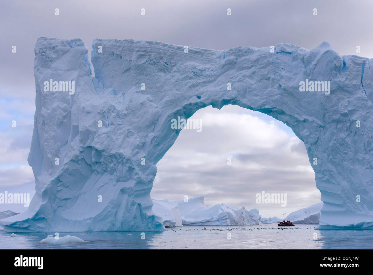 Zodiac Schlauchboot gesehen durch den Bogen eines großen Eisbergs, Pléneau Bay, antarktische Halbinsel, Antarktis Stockfoto