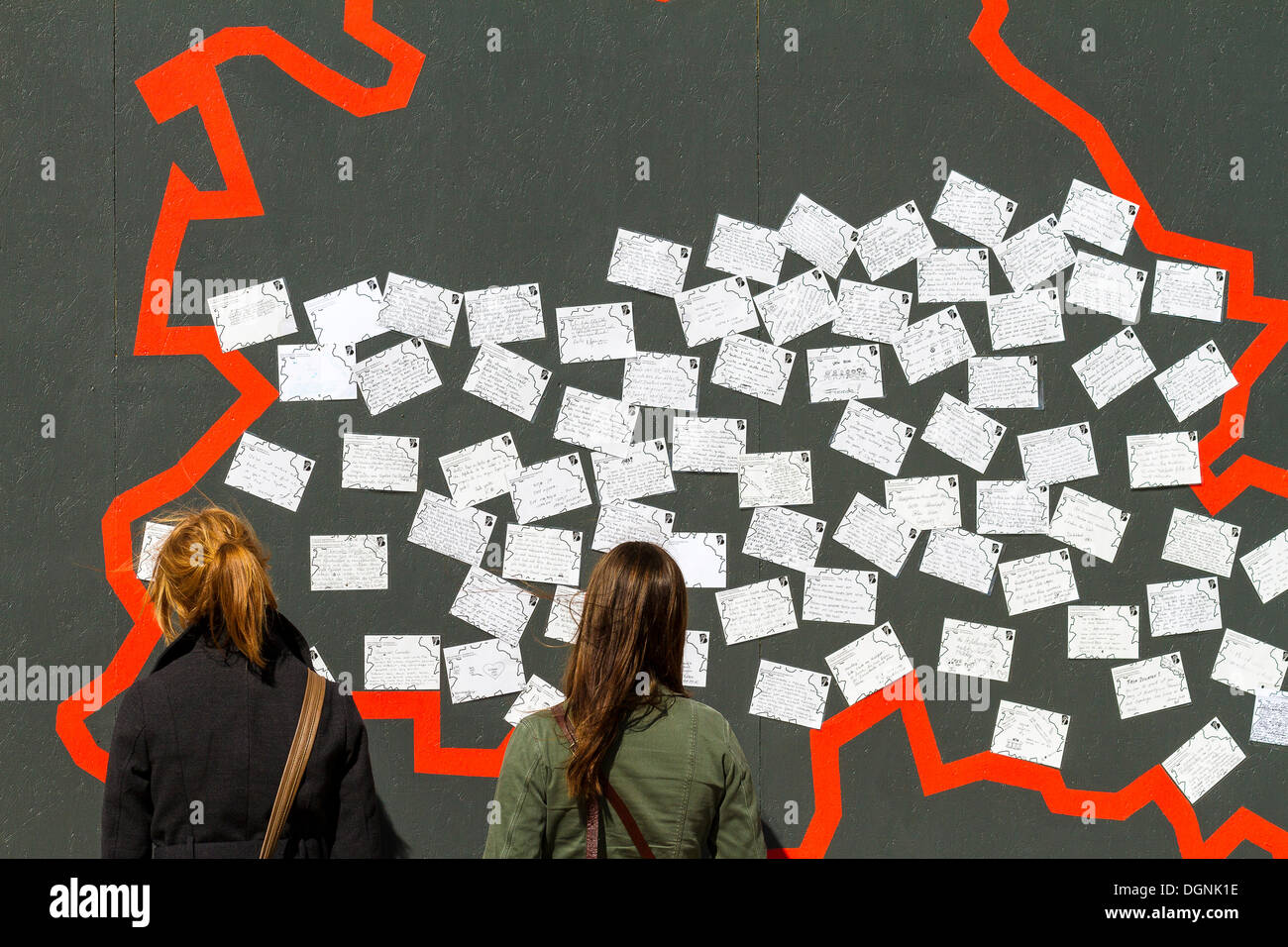 Zwei junge weibliche Touristen stehen vor einer Wand mit Postkarten, Display einrichten zum 775. Jubiläum der Stockfoto