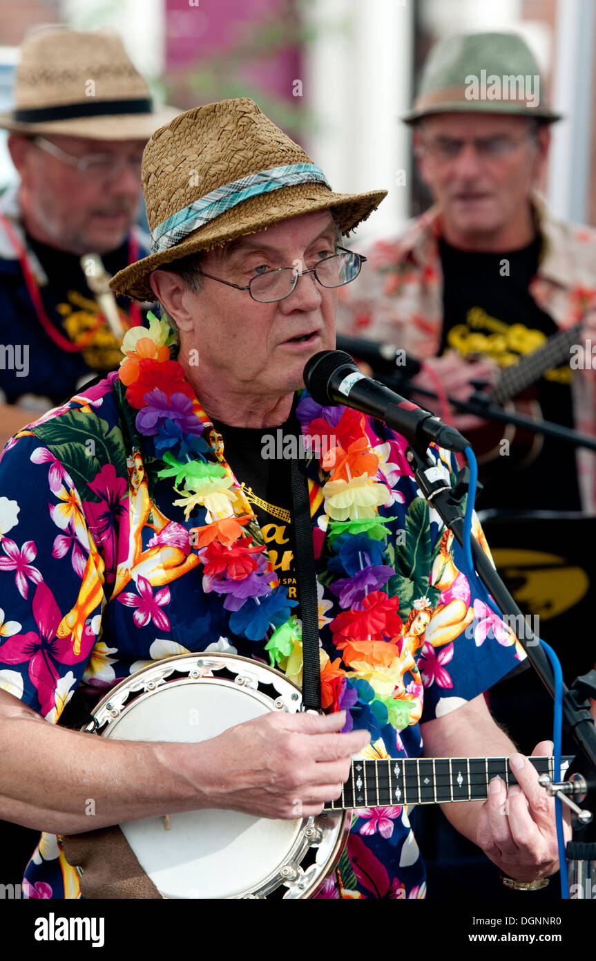 Ein Mann singt und spielt eine Banjo Ukulele, Teil einer Ukulele-Band. Stockfoto