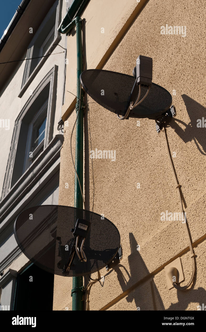 Satellitenschüsseln an der Wand eines Hauses Stockfoto