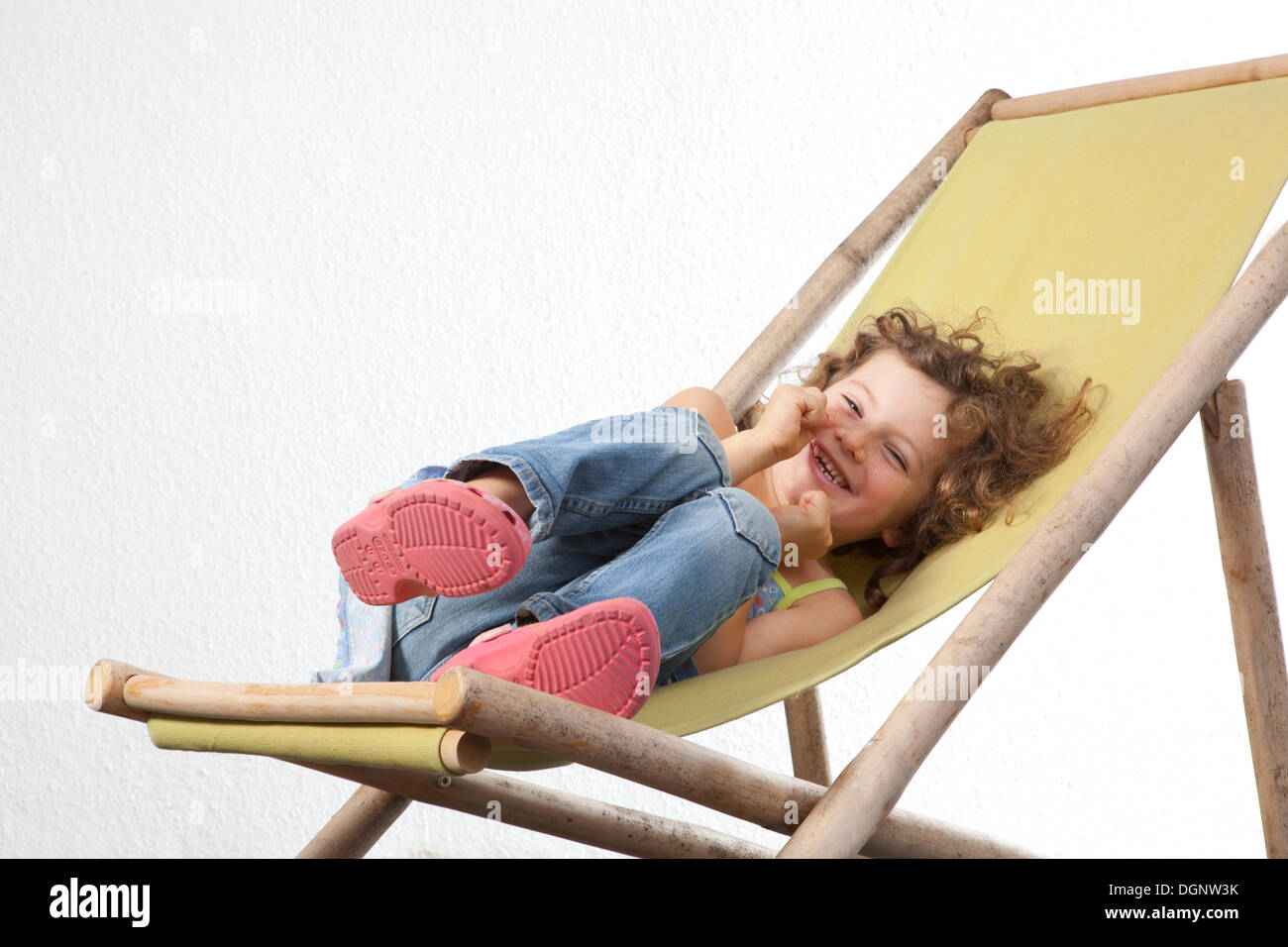 Rothaarige Mädchen, 5 Jahre alt, sitzt auf einem Liegestuhl Stockfoto