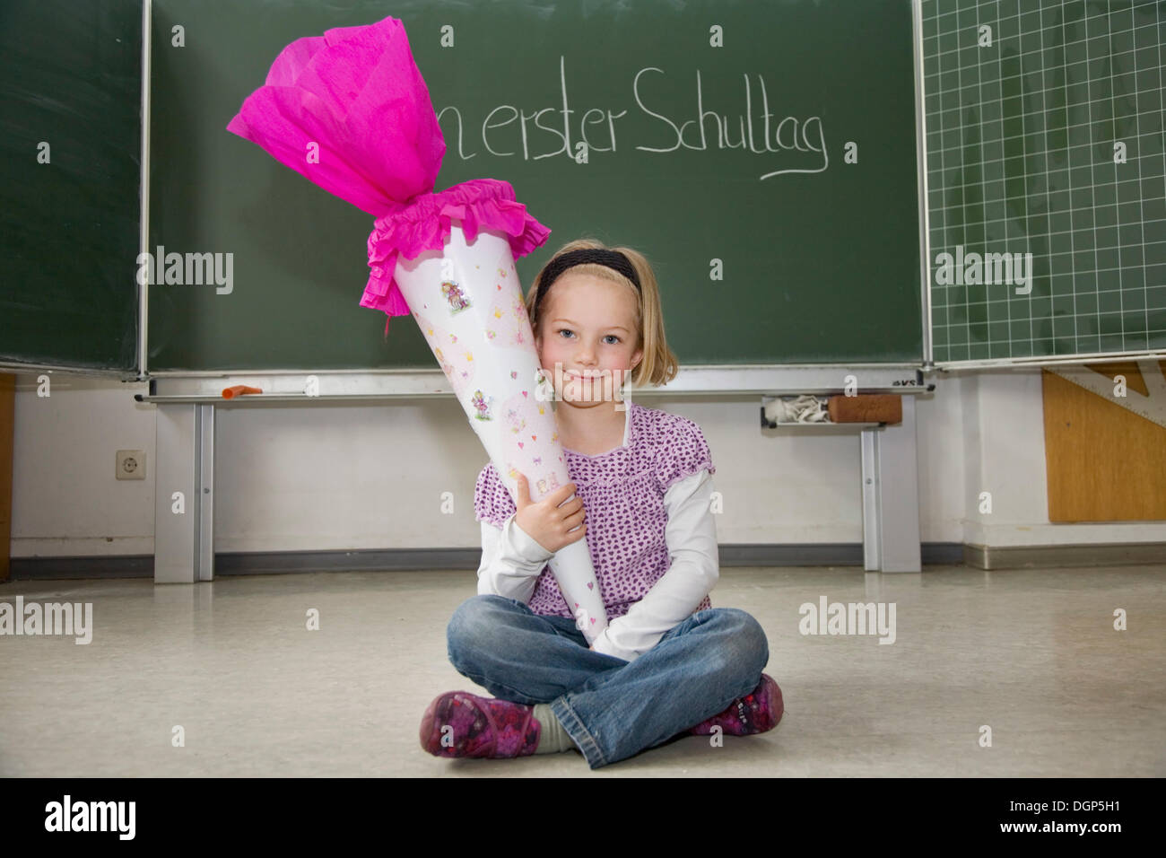 Mädchen mit einem Kegel von Süßigkeiten an ihrem ersten Tag der Schule Stockfoto