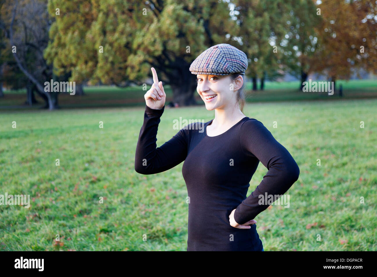 Junge Frau mit Kappe und Zeigefinger index Stockfoto