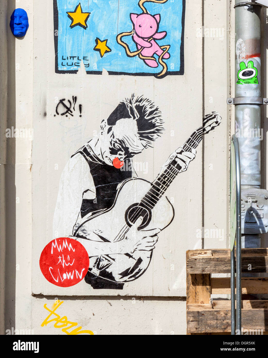 Streetart In Berlin - El Bocho (Little Lucy Cat Tötung Serie) - Mimi der Clown (rote Nase Clown und Gitarre) Stockfoto