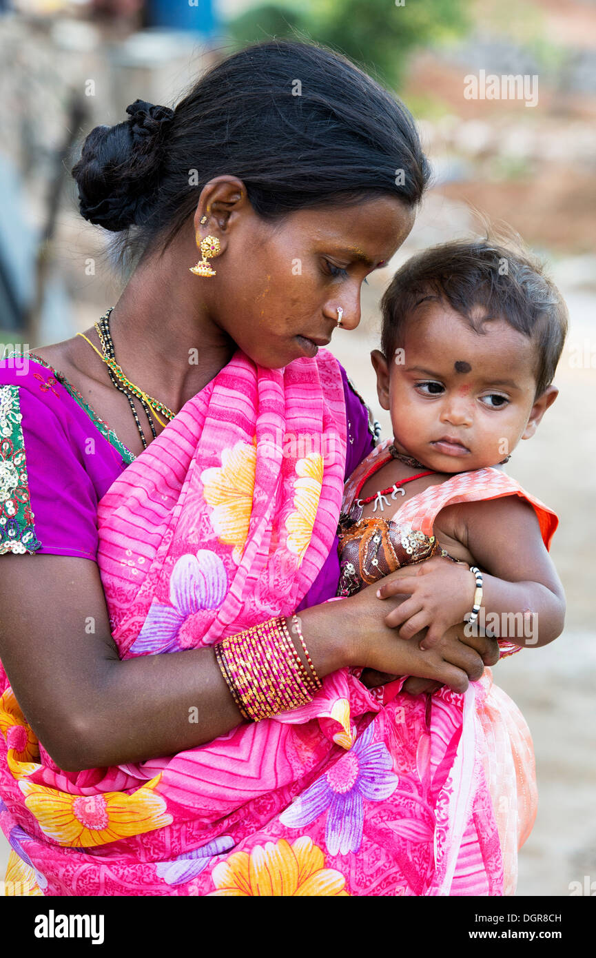 Junge niedrigere Kaste indischen Teenager-Mädchen hält ihr kleines Mädchen. Andhra Pradesh, Indien Stockfoto