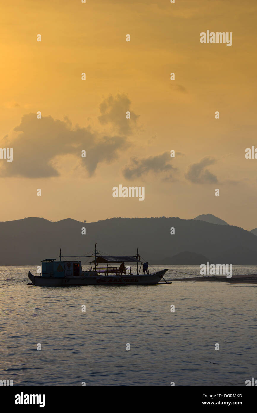 Banka, einem traditionellen philippinischen Auslegerboot, verankert am Strand im Abendlicht, Busuanga, Philippinen, Asien Stockfoto