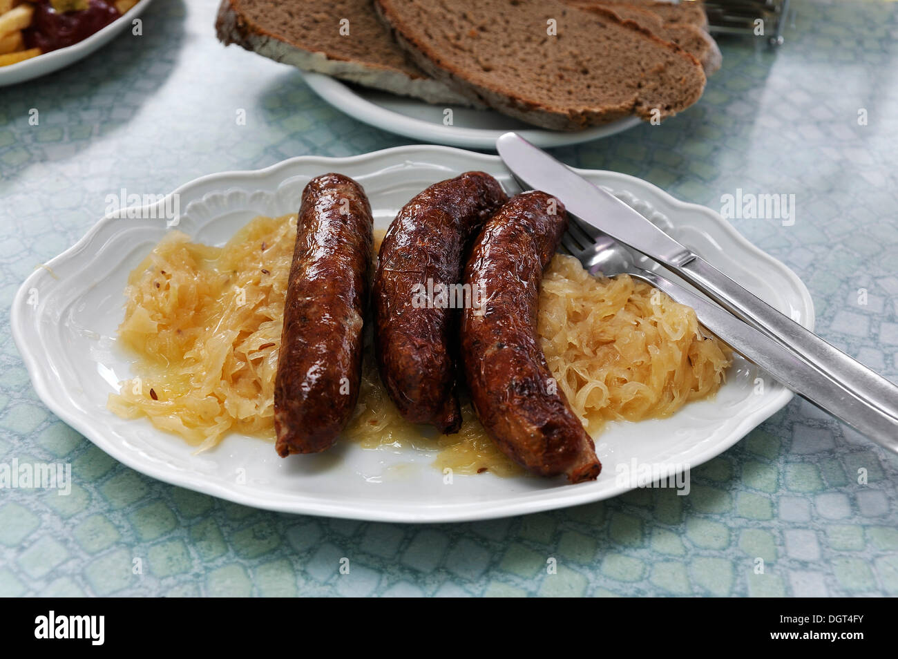 Drei Fränkische Bratwürste mit Sauerkraut auf einer Platte in einer ...
