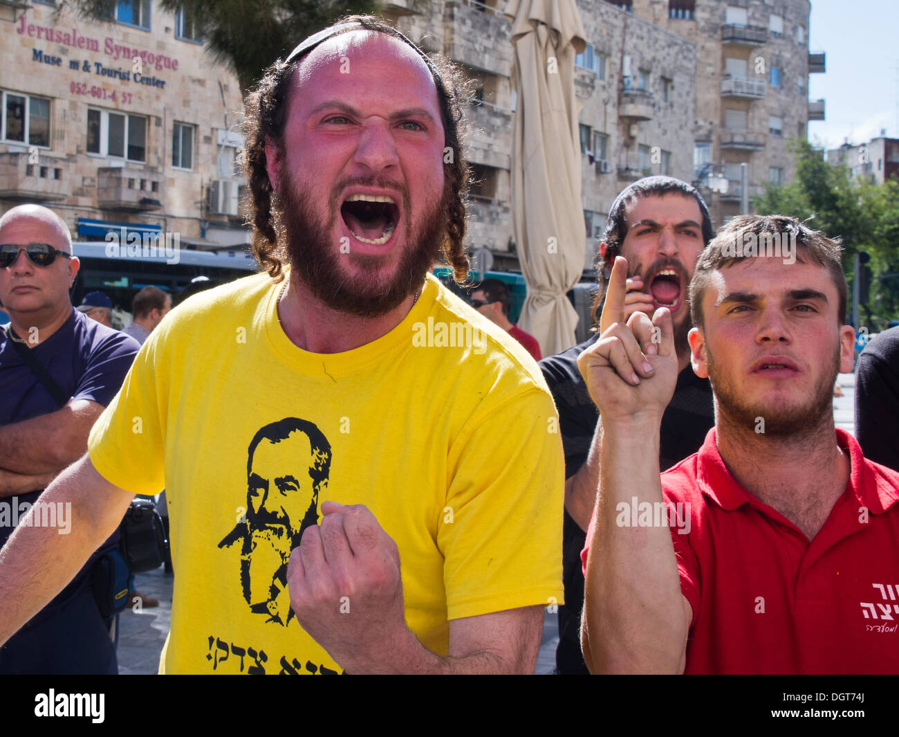 Jerusalem, Israel. 25. Oktober 2013. Rechtsextremismus, jüdischen, religiöse, Demonstranten, hämisch tragen gelbe T-Shirts mit einem Porträt des späten Rabbi Meir Kahane, versuchen, eine Frieden Verhandlung Simulation zur Förderung einer friedlichen Beendigung des israelisch-palästinensischen Konflikts zu stören. Jerusalem, Israel. 25. Oktober 2013.  Pro-Friedensaktivisten engagieren in einer basisdemokratischen israelisch-palästinensischen Frieden Verhandlung Simulation in einer der belebtesten Plätze der Stadt in einem Versuch zu beweisen, dass die Menschen beider Nationen erreichen können, was Politiker nicht. Bildnachweis: Nir Alon/Alamy Live-Nachrichten Stockfoto