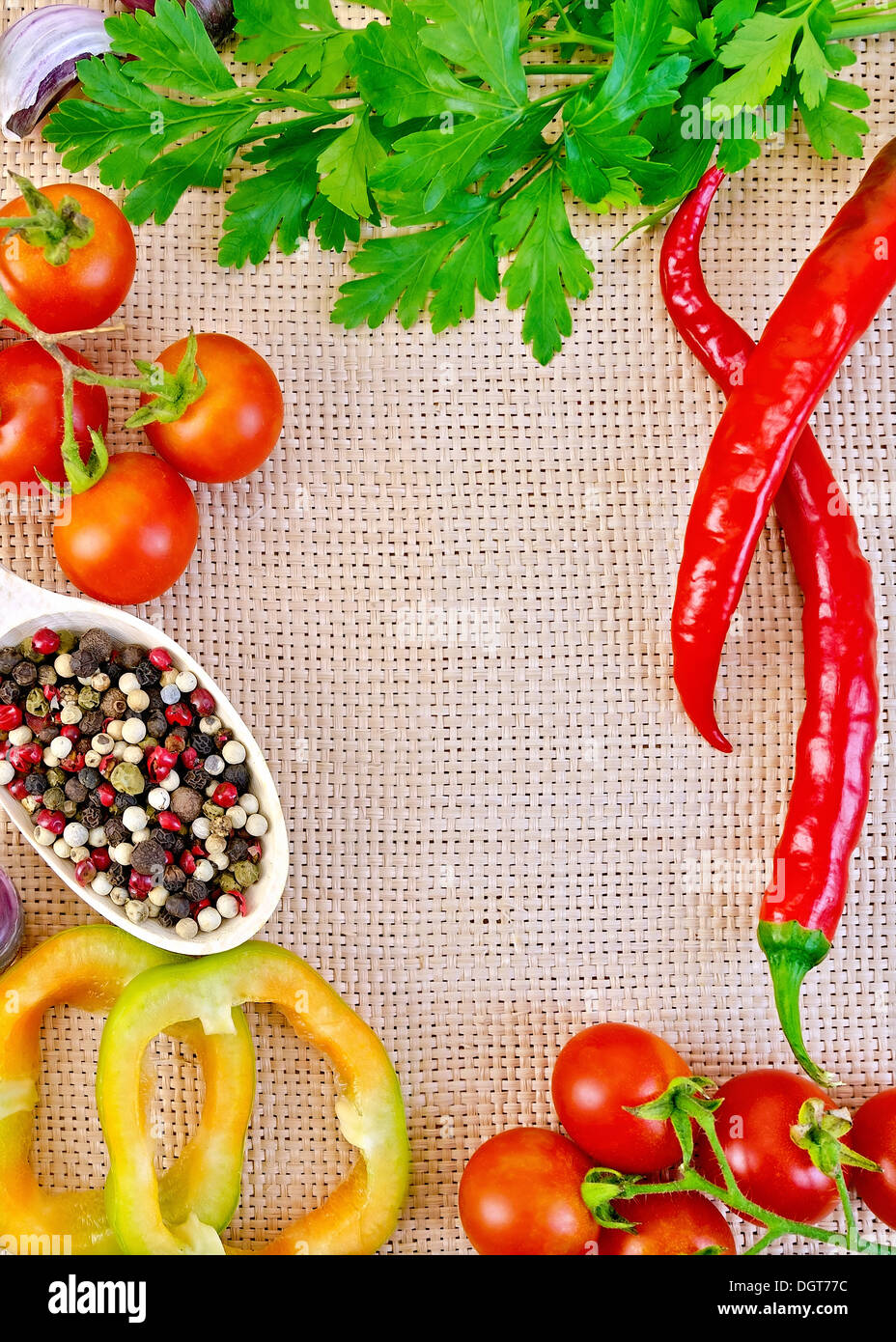 Rahmen von süß und Peperoni, Tomaten, Erbsen verschiedene Pfeffer in Holzlöffel, Petersilie und Knoblauch auf Entlassung Stockfoto