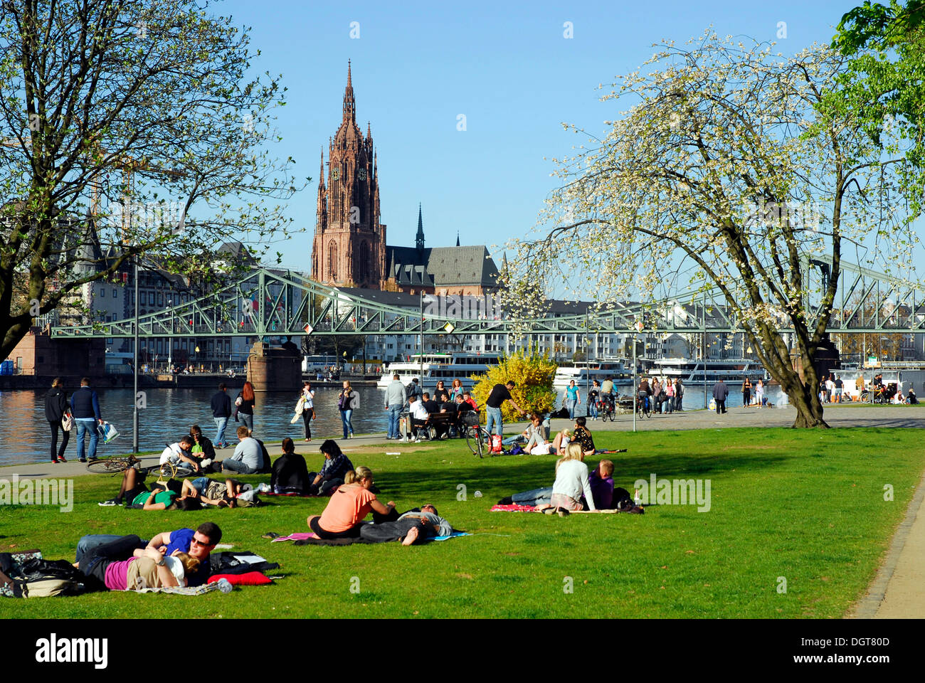 Menschen am Ufer des Mains, Schaumain Kai, Museumsufer, vor der Hängebrücke Eiserner Steg und Stockfoto
