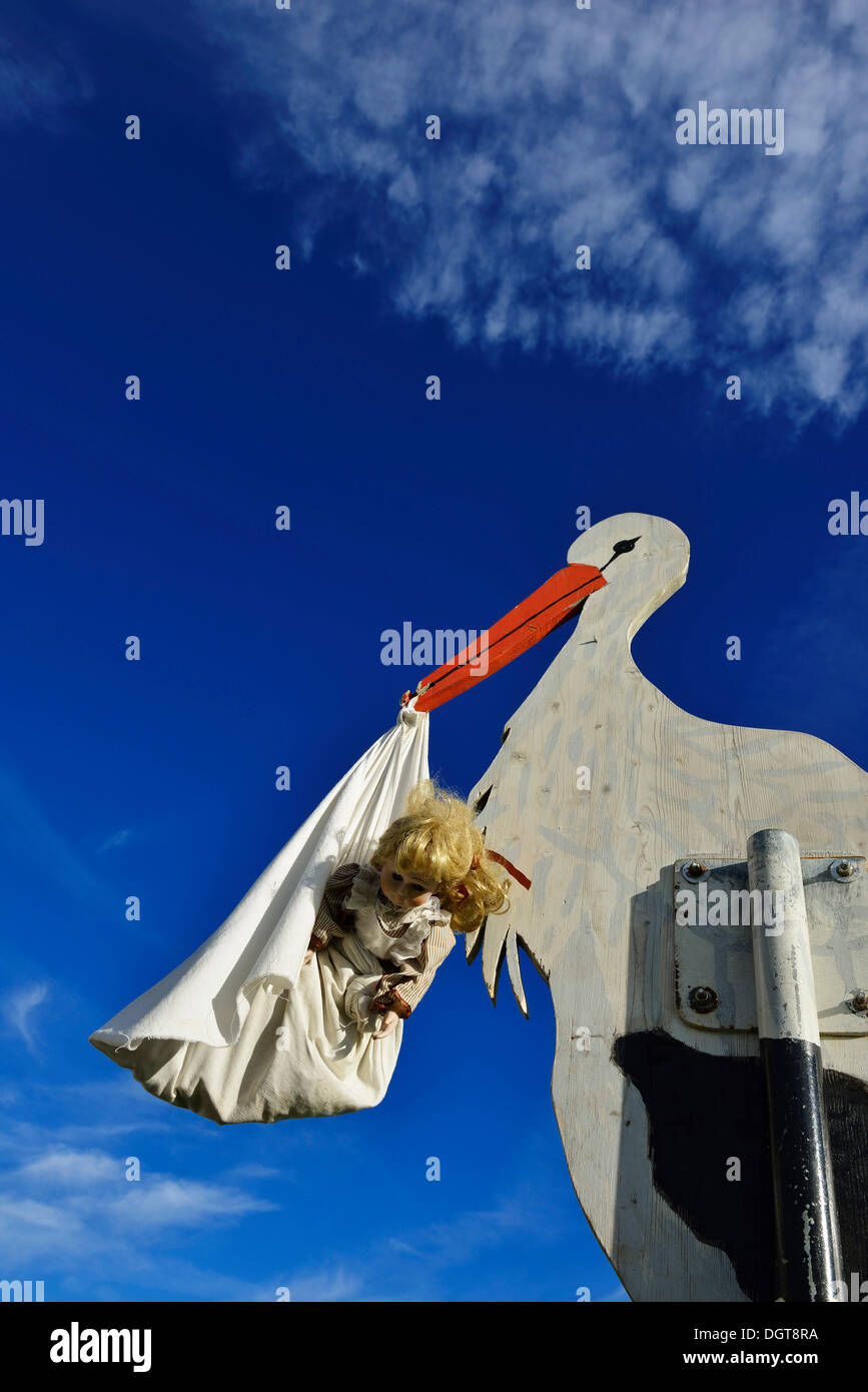Storch bringt Baby, hölzerne Figur, Tannberg Berg, Koestendorf, Waller See, Seen-Region Salzburg, Salzburg, Österreich Stockfoto