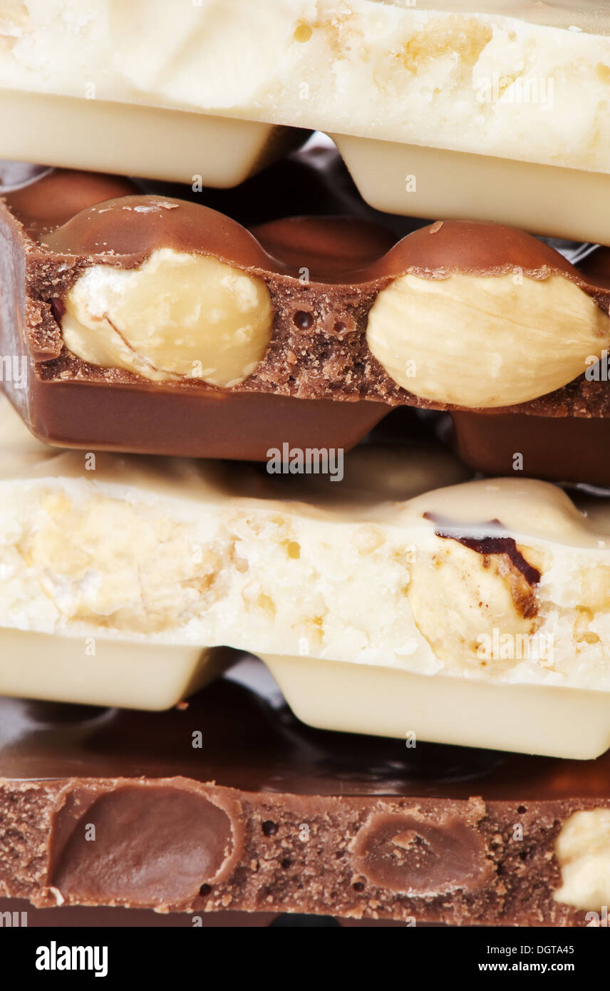 Stapel von dunkle und weiße Schokolade Blöcken mit Haselnüssen Stockfoto