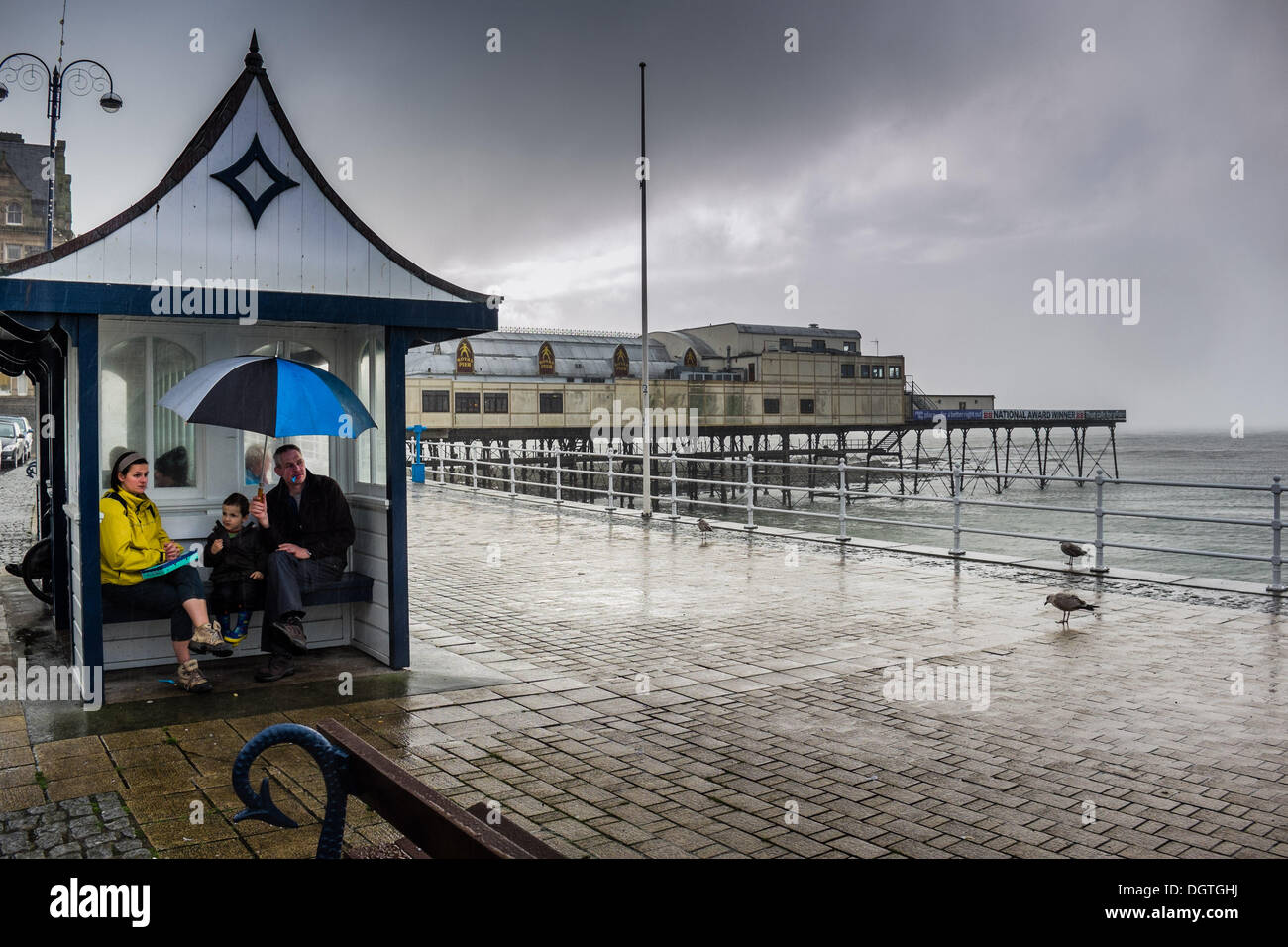 Aberystwyth Wales UK, 25. Oktober 2013 Familie Zuflucht aus dem gewittriger Starkregen fegt in das Meer bei Aberystwyth im Westen wales Küste. Das Wetter im Westen und Süden der UK wird voraussichtlich drastisch stürmischer umdrehen der nächsten 48 Stunden, mit Windgeschwindigkeiten von bis zu 90 km/h Prognose für viele südliche Grafschaften-Credit Foto: Keith Morris/Alamy Live-Nachrichten Stockfoto