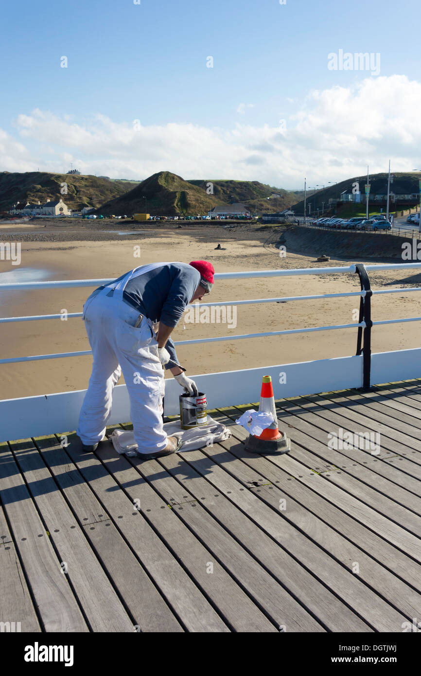 Maler bei der Arbeit, die Neulackierung der Handläufe auf Saltburn Pier Stockfoto