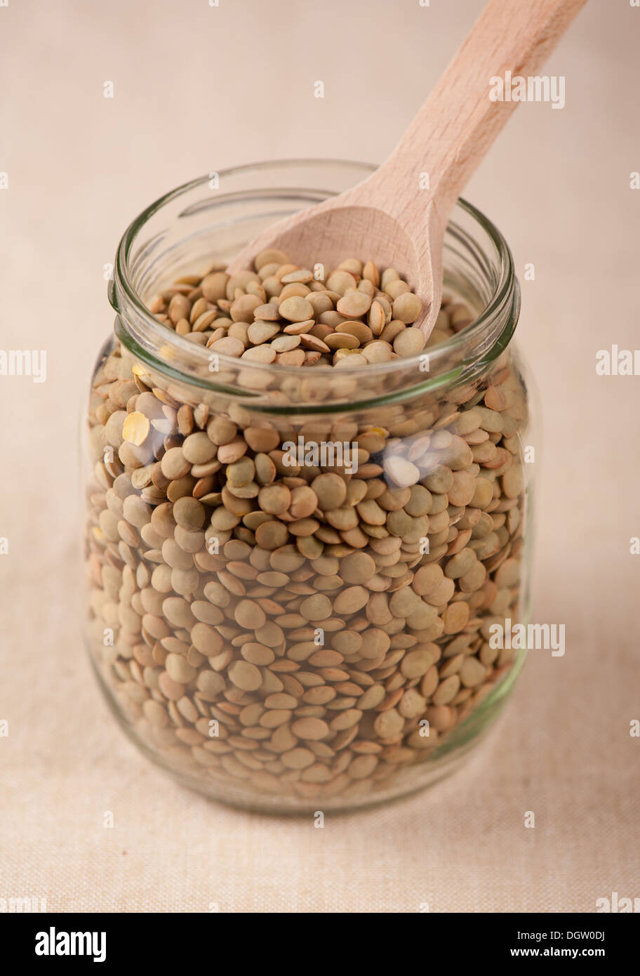 Grüne Linsen Samen und Holzlöffel in Glas Stockfoto