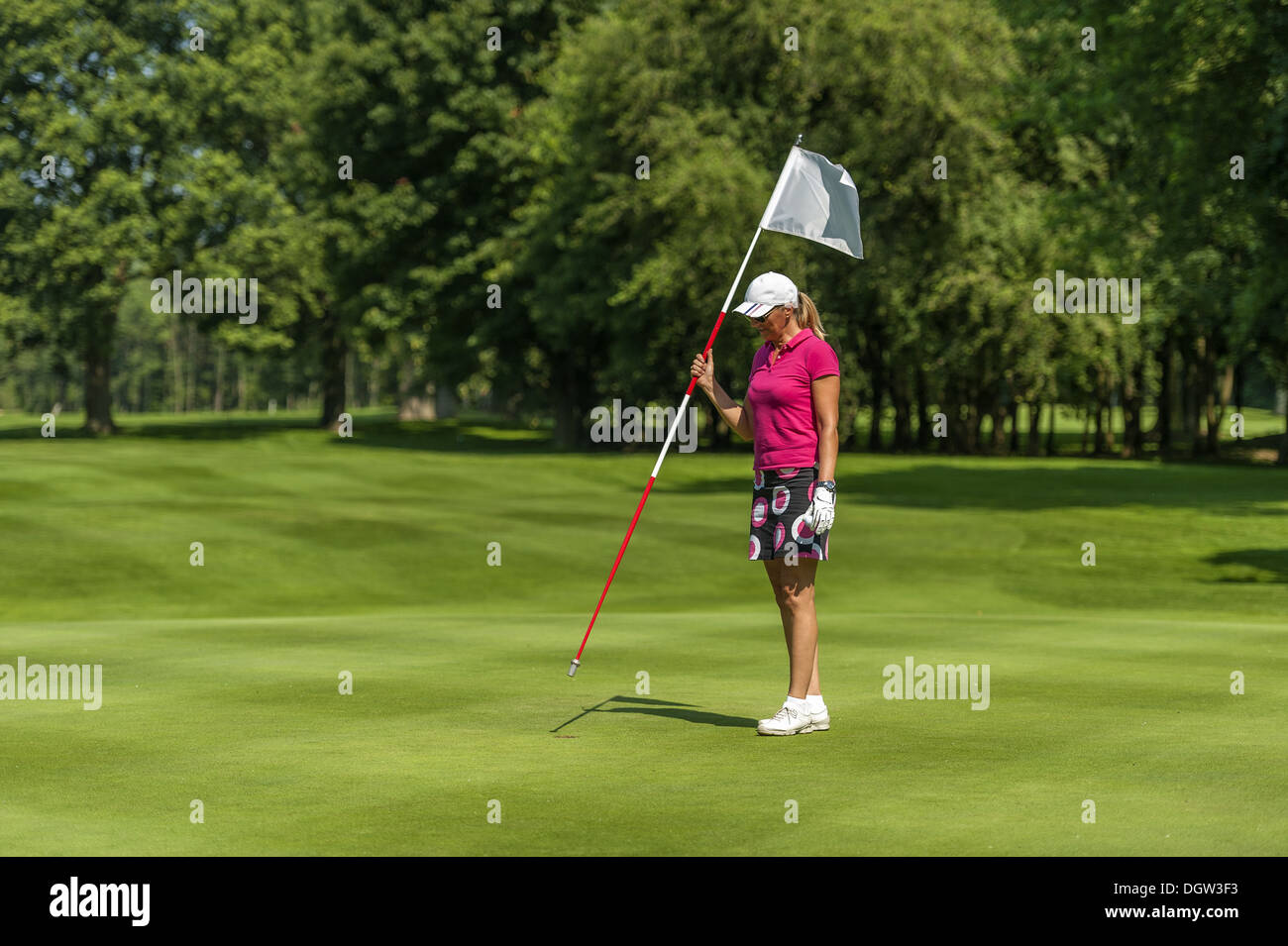 Golfer, die Fahne im Loch zurück Stockfoto