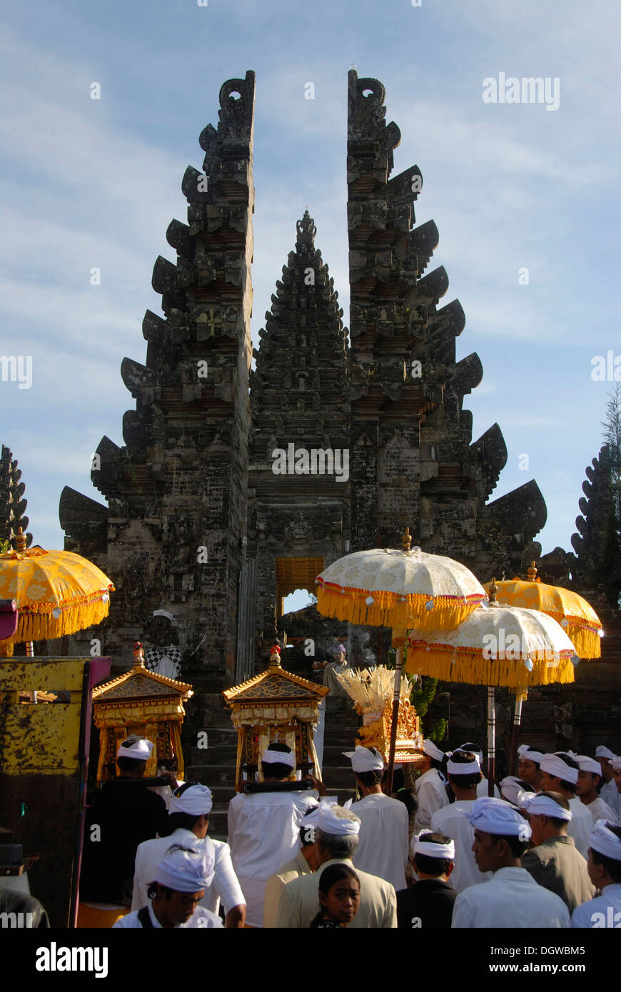 Balinesischen Hinduismus, Versammlung von Gläubigen, die Zeremonie, die Gläubigen im Tempel-Kleid mit Sonnenschirmen, Tor, Candi Bentar aufgeteilt Stockfoto