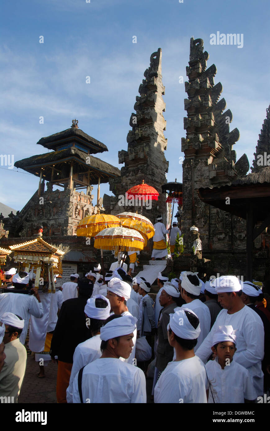 Balinesischen Hinduismus, Versammlung von Gläubigen, die Zeremonie, die Gläubigen in weißen Tempel-Kleid mit bunten Sonnenschirmen, Tor aufgeteilt Stockfoto