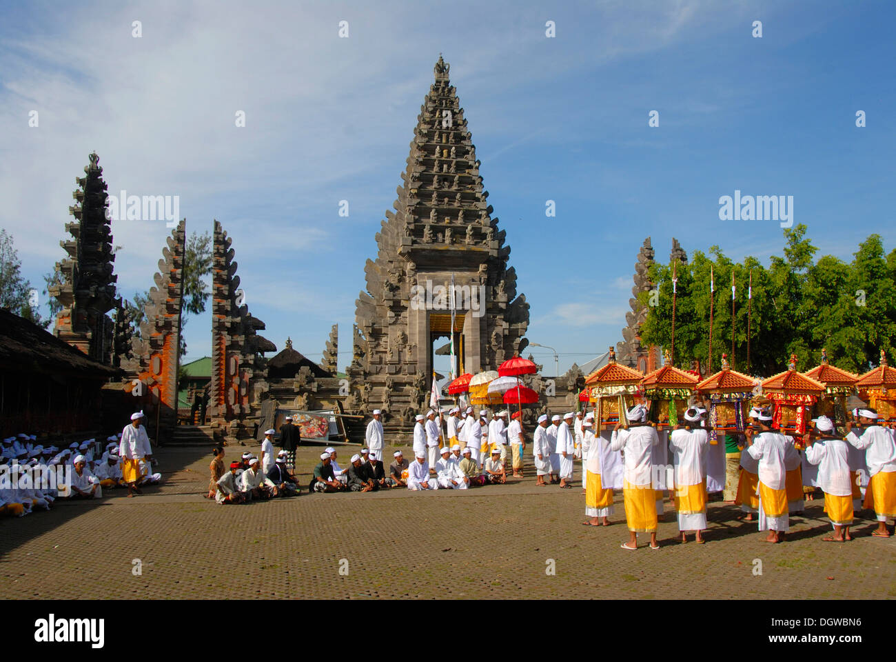 Balinesischen Hinduismus, Versammlung von Gläubigen, die Zeremonie, die Gläubigen im hellen Tempel Kleid mit bunten Sonnenschirmen und Schreine, Stockfoto