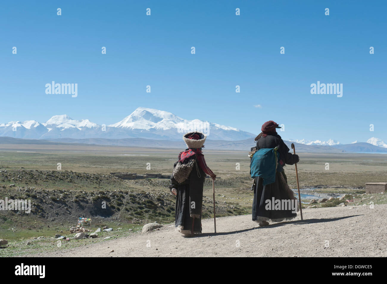 Tibetischen Buddhismus, zwei Pilger Wandern, gekleidet in traditioneller Tracht hinter Mt. Gurla Mandhata Pilgern entlang der Stockfoto