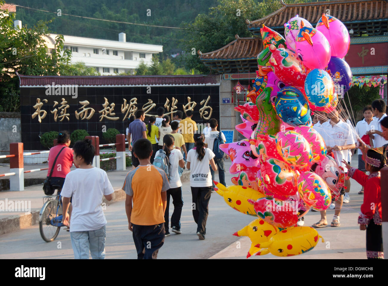 Menschen zu Fuß entlang der Straße, Kitsch, bunte Luftballons, Jiangcheng, Pu'er Stadt, Yunnan Provinz, Volksrepublik China Stockfoto