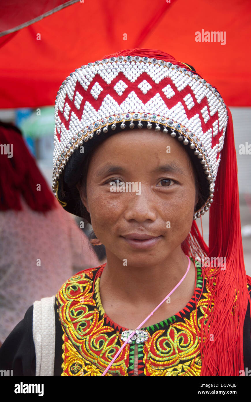 Frau Yi oder Hani Volksgruppe tragen bunte Pompon auf einem Festival, Porträt, Jiangcheng, Pu'er Stadt Stockfoto