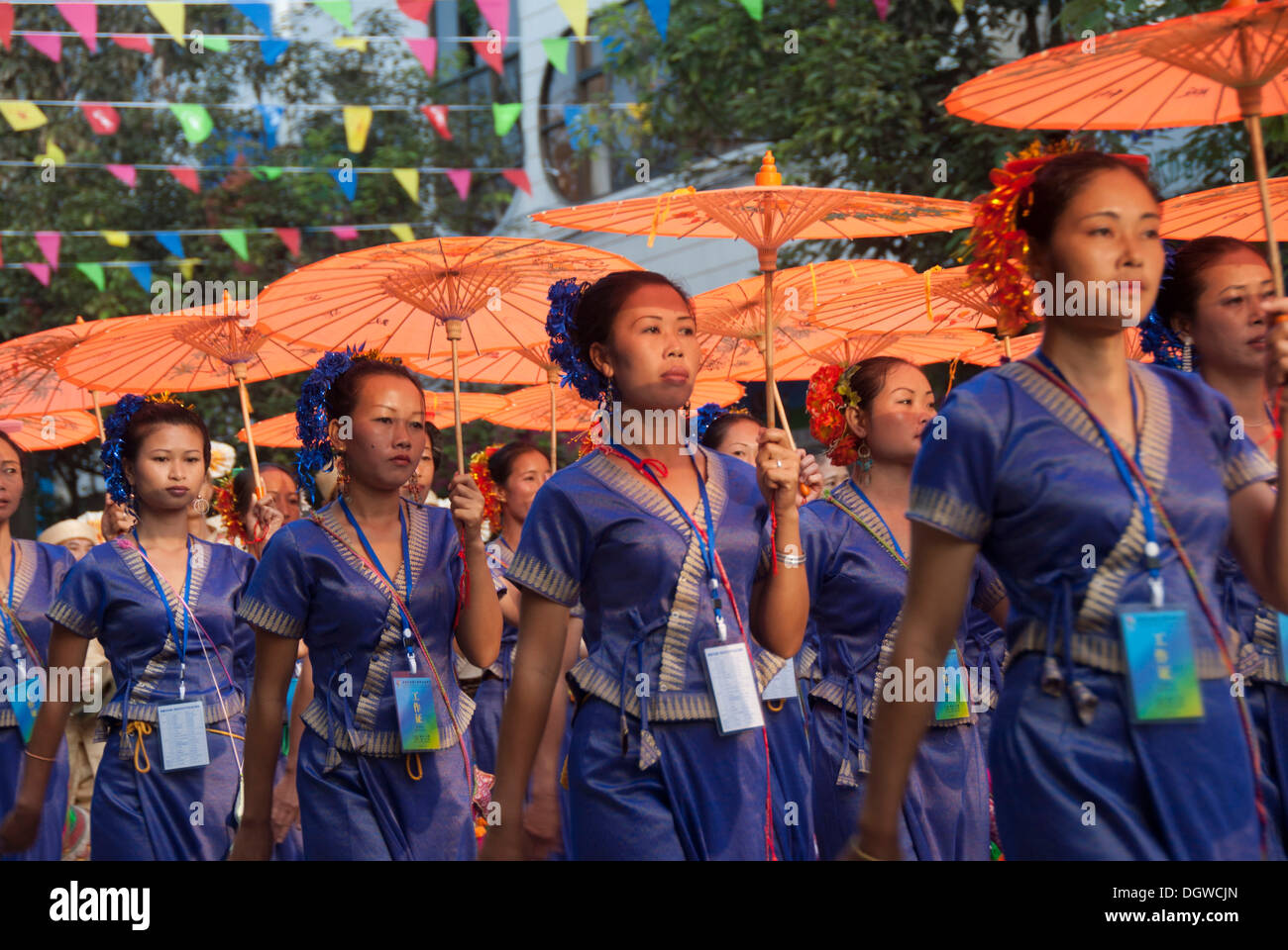 Tanz-Performance auf einem Festival, Frauen aus Vietnam marschieren, blaue Kleider tragen und tragen orange Sonnenschirme, Jiangcheng Stockfoto