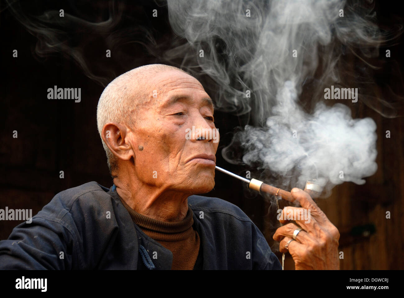Männliche Raucher, Porträt, Genuss, Alter Mann von der ethnischen Gruppe der Mouchi raucht eine Pfeife, Rauch in der Luft verweilen Stockfoto