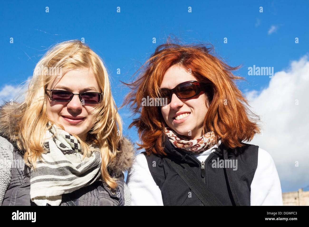 Porträt von zwei glücklichen Freundinnen über blauen Himmel. Stockfoto