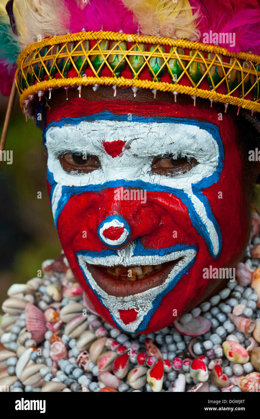 Mitglied eines Stammes in einem bunt geschmückten Kostüm mit Gesichtsbemalung feiert bei der traditionellen Sing Sing in sammeln Stockfoto