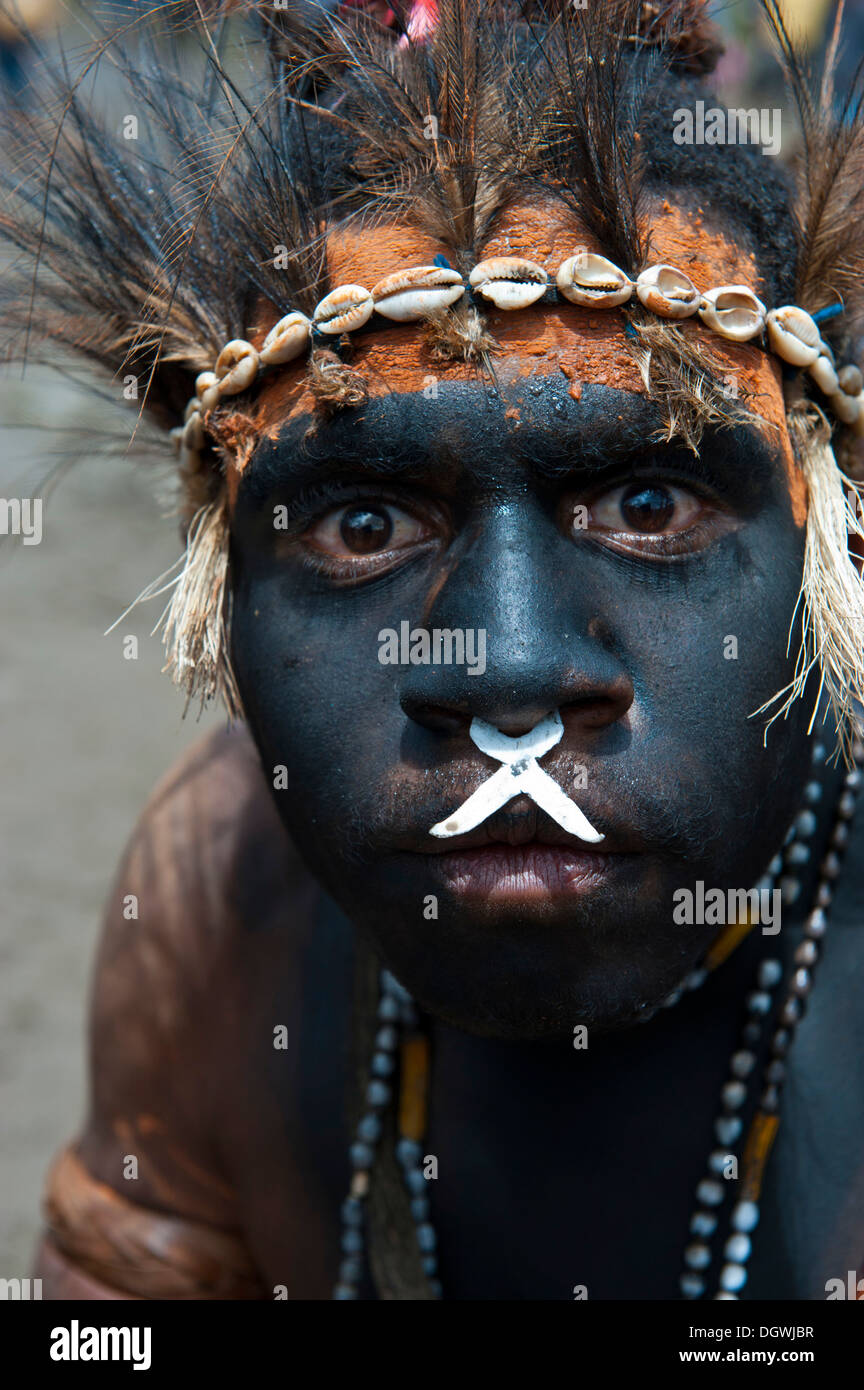 Schwarz lackiert und dekoriert Man während der traditionellen Sing Sing in den Highlands, Enga, Hochland, Papua-Neu-Guinea Stockfoto