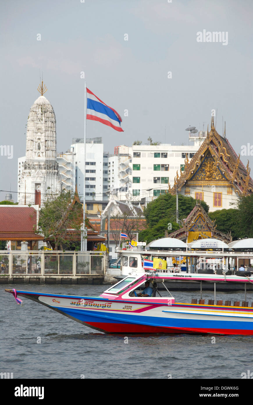 Boot auf dem Mae Nam Chao Phraya River, thailändische Nationalflagge in den Rücken eines buddhistischen Tempels, Bangkok, Thailand, Südostasien Stockfoto