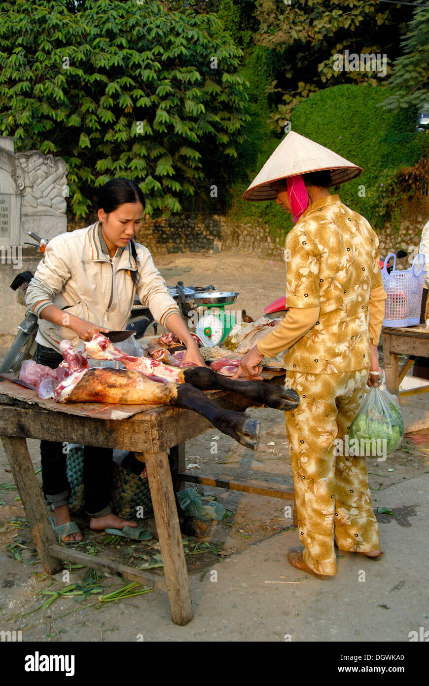 Vietnamesin einen Reis-Hut mit der Markt-Verkäuferin über den Verkauf der Beine von Rindfleisch Stockfoto