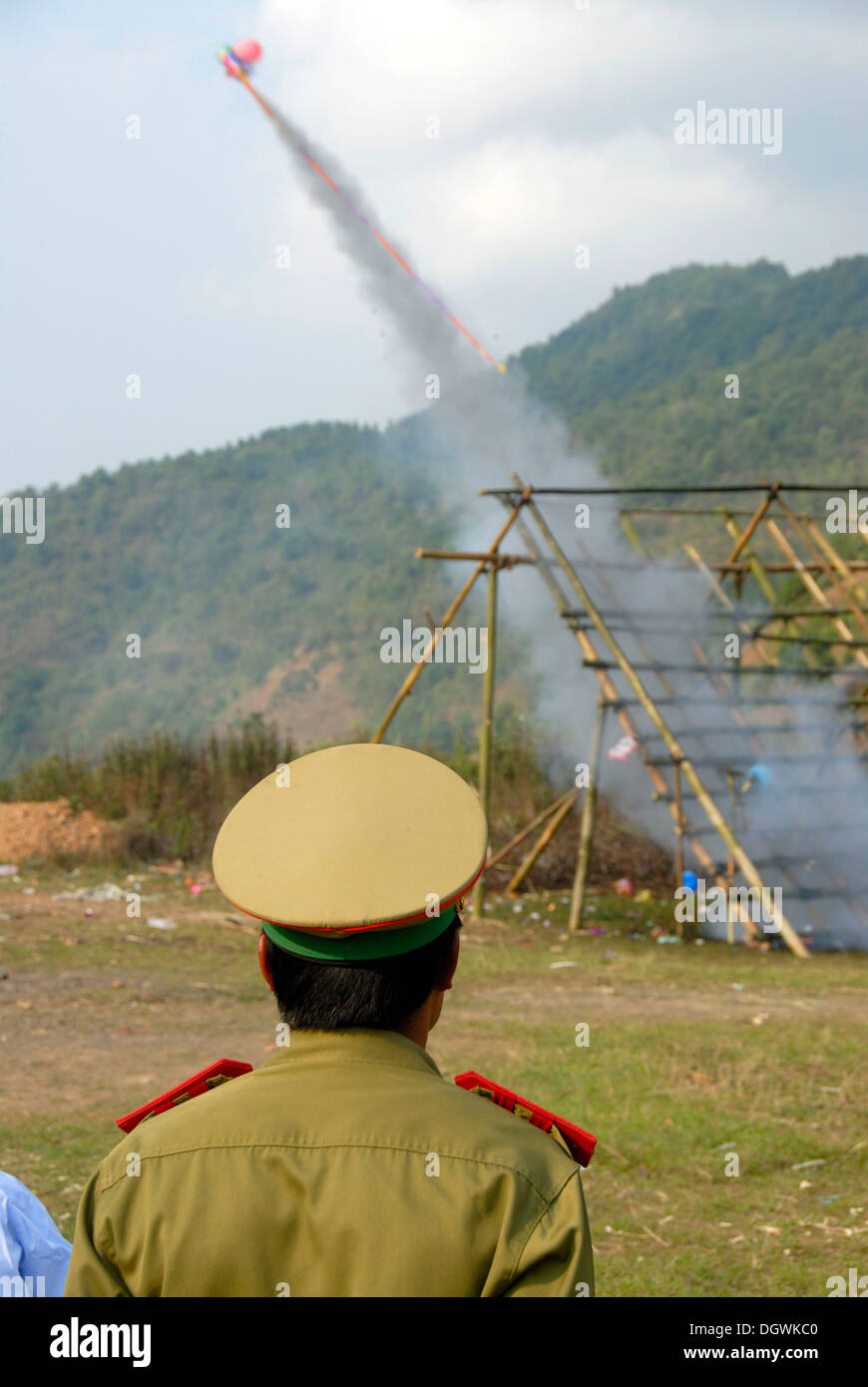 Laotische Pi Mai Neujahrsfest, Start einer Rakete bang Fai Rakete abfeuern, Polizist mit einer Schirmmütze, Phongsali, Laos Stockfoto