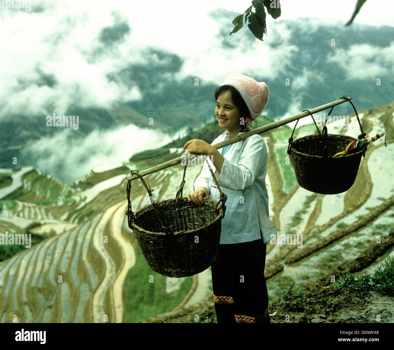Frau, die Körbe mit einem Schulter-Pol Reisterrassen von Yuanyang, Yunnan, China, Asien Stockfoto